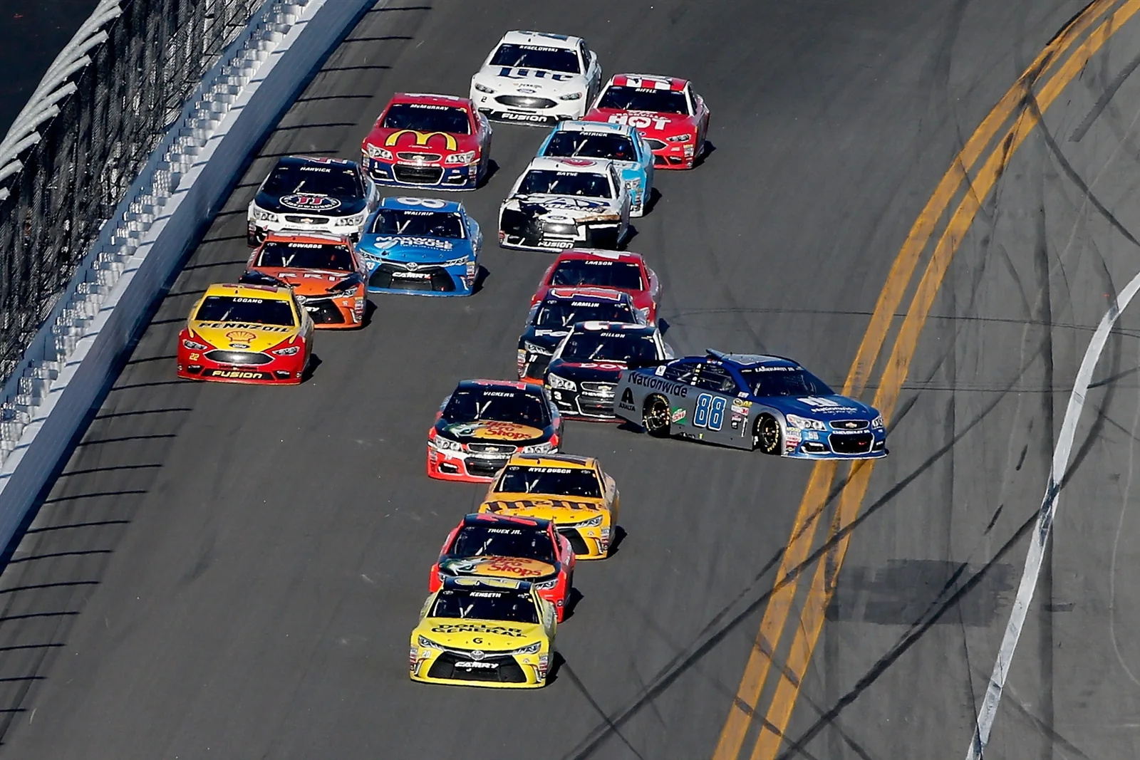 NASCAR Cup cars racing in a tight pack on the Daytona International Speedway banking