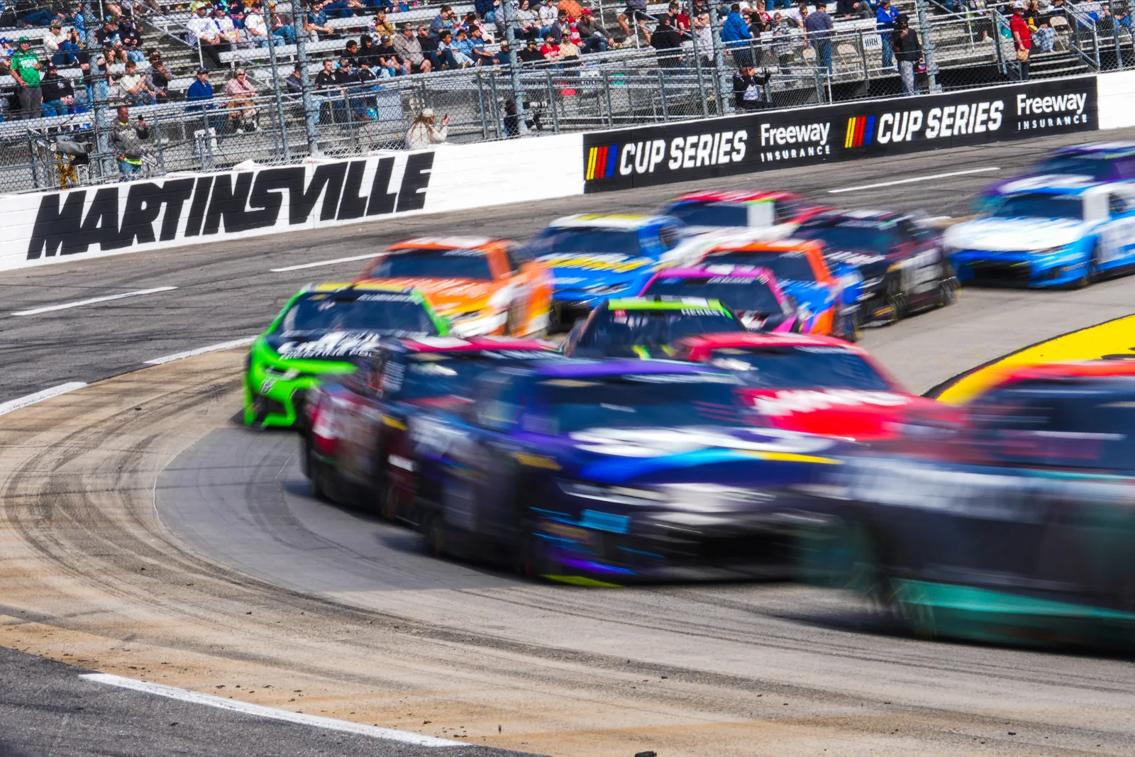 NASCAR Cup Series cars crowding through a turn at Martinsville Speedway in 2026